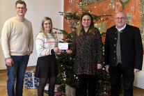 4 Personen stehen vor einem Christbaum